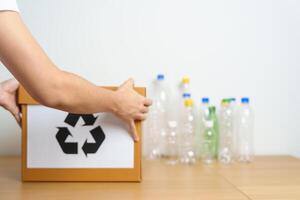 Volunteer keep plastic bottle into paper box at home or office. Hand Sorting Recycle garbage. Ecology, Environmental, pollution, Dispose recycling, waste management and trash Separation concept photo