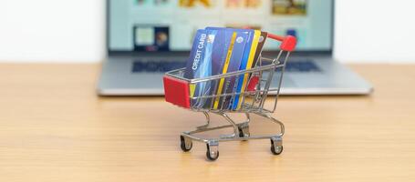 Shopping cart with Credit Cart and laptop computer with marketplace website. Online Shopping, technology, ecommerce, SEO, Search Engine Optimization, Advertising, keyword and online payment concept photo