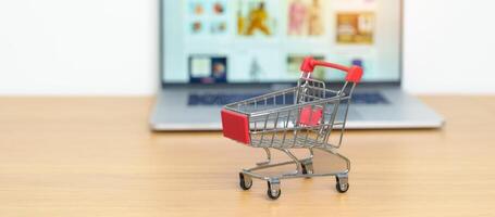 Shopping cart and laptop computer with marketplace website. Online Shopping, technology, ecommerce, SEO, Search Engine Optimization, Advertising, keyword and online payment concept photo