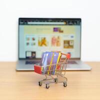 Shopping cart with Credit Cart and laptop computer with marketplace website. Online Shopping, technology, ecommerce, SEO, Search Engine Optimization, Advertising, keyword and online payment concept photo