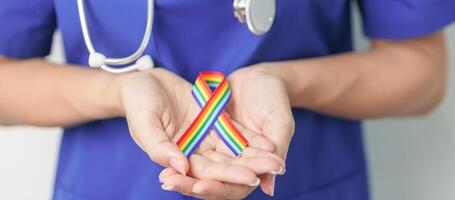 Doctor with LGBTQ Rainbow ribbon for Support Lesbian, Gay, Bisexual, Transgender and Queer community and happy Pride month concept photo