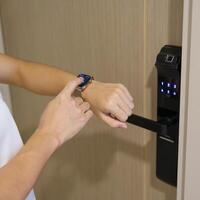 Hand using smartwatch for open digital door lock at home or apartment. NFC Technology, Fingerprint scan, keycard, PIN number, smartphone, electrical and contactless lifestyle concepts photo