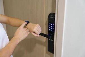 Hand using smartwatch for open digital door lock at home or apartment. NFC Technology, Fingerprint scan, keycard, PIN number, smartphone, electrical and contactless lifestyle concepts photo