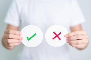 Woman show Wrong and Right symbol paper. True and false, accept and rejected, evaluation, Vote, Poll, Yes or No and Survey concepts photo