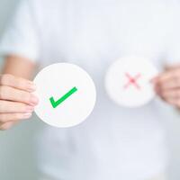 Woman show Right symbol paper. True and false, accept and rejected, evaluation, Vote, Poll, Yes or No and Survey concepts photo
