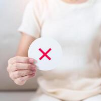 Woman show Wrong symbol paper. True and false, accept and rejected, evaluation, Vote, Poll, Yes or No and Survey concepts photo