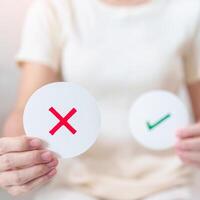 Woman show Wrong symbol paper. True and false, accept and rejected, evaluation, Vote, Poll, Yes or No and Survey concepts photo