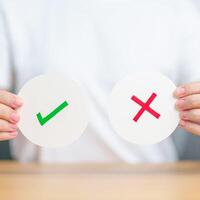 Woman show Wrong and Right symbol paper. True and false, accept and rejected, evaluation, Vote, Poll, Yes or No and Survey concepts photo