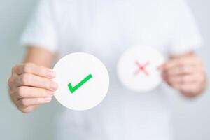 Woman show Right symbol paper. True and false, accept and rejected, evaluation, Vote, Poll, Yes or No and Survey concepts photo