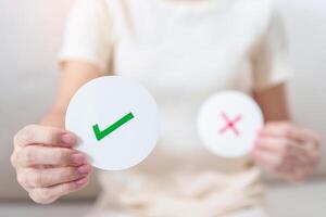 Woman show Right symbol paper. True and false, accept and rejected, evaluation, Vote, Poll, Yes or No and Survey concepts photo