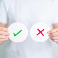 Woman show Wrong and Right symbol paper. True and false, accept and rejected, evaluation, Vote, Poll, Yes or No and Survey concepts photo
