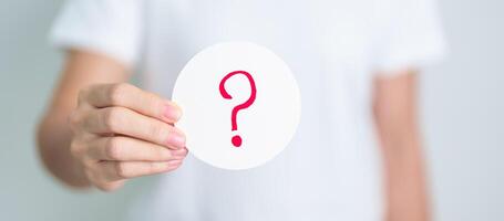 Woman show Questions Mark on paper. FAQ, frequency asked questions, Answer, Q and A, Information, Communication and interrogation Concepts photo