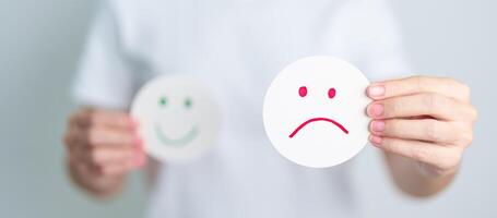 Woman show Unhappy Sad face paper, Mental health Assessment, Psychology, Health Wellness, Feedback, Customer Review, Experience, Satisfaction Survey, Negative Thinking and World Mental Health day photo