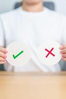 Woman show Wrong and Right symbol paper. True and false, accept and rejected, evaluation, Vote, Poll, Yes or No and Survey concepts photo