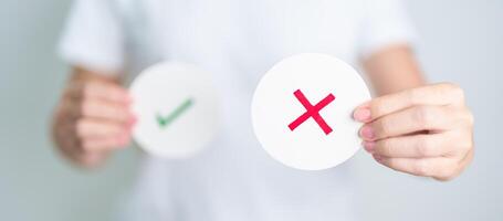 Woman show Wrong symbol paper. True and false, accept and rejected, evaluation, Vote, Poll, Yes or No and Survey concepts photo