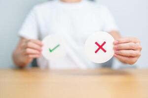 Woman show Wrong symbol paper. True and false, accept and rejected, evaluation, Vote, Poll, Yes or No and Survey concepts photo