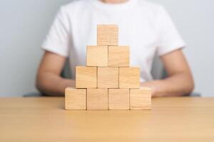 hand placing or pulling wooden block on the building. Business planning, Risk Management, Solution and strategy Concepts photo