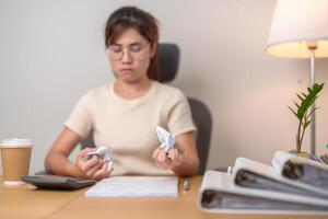 stressed Asian Woman with mistake paper, Tired female businesswoman working overload at office, Exhausted casual woman with documents folder stack at late night in home. Failure, Problem and business photo