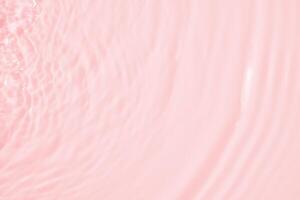 Abstract transparent water shadow surface texture natural ripple on pink background photo