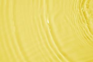 Abstract transparent water shadow surface texture natural ripple on yellow background photo