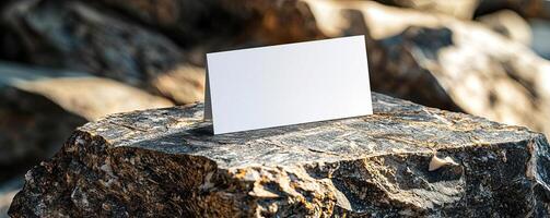 Business card mockup stands on top of a piece of granite photo