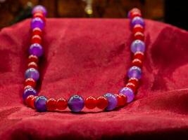 display of ancient medieval colored pearl necklace on a red fabric photo