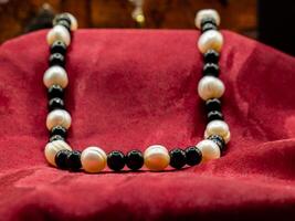 display of ancient medieval colored pearl necklace on a red fabric photo