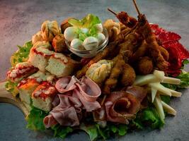 close up shot of a plate of salty snacks on a tray for an Italian aperitif or appetizers for a party photo