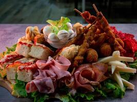 close up shot of a plate of salty snacks on a tray for an Italian aperitif or appetizers for a party photo