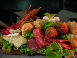 close up shot of a plate of salty snacks on a tray for an Italian aperitif or appetizers for a party photo