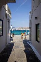 Whitewashed alley with stairs and colorful doors and windows in Mykonos, Greece. Traditional Cycladic architecture. photo