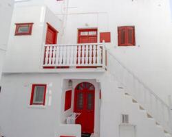 Whitewashed alley with stairs and colorful doors and windows in Mykonos, Greece. Traditional Cycladic architecture. photo