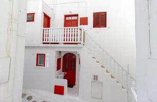 Whitewashed alley with stairs and colorful doors and windows in Mykonos, Greece. Traditional Cycladic architecture. photo