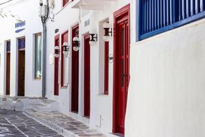 Whitewashed alley with stairs and colorful doors and windows in Mykonos, Greece. Traditional Cycladic architecture. photo