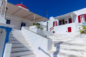 Whitewashed alley with stairs and colorful doors and windows in Mykonos, Greece. Traditional Cycladic architecture. photo