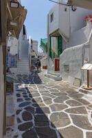 Whitewashed alley with stairs and colorful doors and windows in Mykonos, Greece. Traditional Cycladic architecture. photo