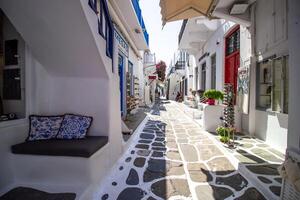 Whitewashed alley with stairs and colorful doors and windows in Mykonos, Greece. Traditional Cycladic architecture. photo