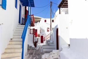 Whitewashed alley with stairs and colorful doors and windows in Mykonos, Greece. Traditional Cycladic architecture. photo