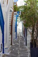 Whitewashed alley with stairs and colorful doors and windows in Mykonos, Greece. Traditional Cycladic architecture. photo