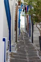 Whitewashed alley with stairs and colorful doors and windows in Mykonos, Greece. Traditional Cycladic architecture. photo