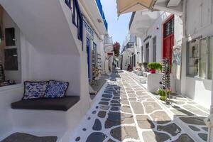 Whitewashed alley with stairs and colorful doors and windows in Mykonos, Greece. Traditional Cycladic architecture. photo