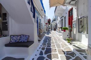 Whitewashed alley with stairs and colorful doors and windows in Mykonos, Greece. Traditional Cycladic architecture. photo