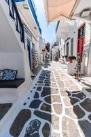 Whitewashed alley with stairs and colorful doors and windows in Mykonos, Greece. Traditional Cycladic architecture. photo