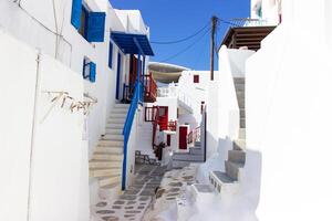 Whitewashed alley with stairs and colorful doors and windows in Mykonos, Greece. Traditional Cycladic architecture. photo