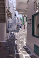 Whitewashed alley with stairs and colorful doors and windows in Mykonos, Greece. Traditional Cycladic architecture. photo