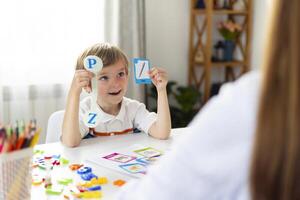 Boy learning letters in classroom setting photo