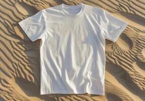 White t-shirt on sand texture. Casual blank shirt textile. Empty mock up cloth collection. Cotton tshirt in nature coastline background. Mockup blank fashion desert design photo
