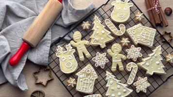 Christmas cookies cooling on a rack, with a rolling pin and cookie cutters in the background video