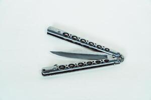Partially open silver balisong or butterfly knife isolated on white background. Close-up of a sharp balisong knife or butterfly knife in various positions on a white background photo