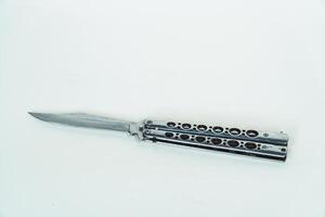 Partially open silver balisong or butterfly knife isolated on white background. Close-up of a sharp balisong knife or butterfly knife in various positions on a white background photo